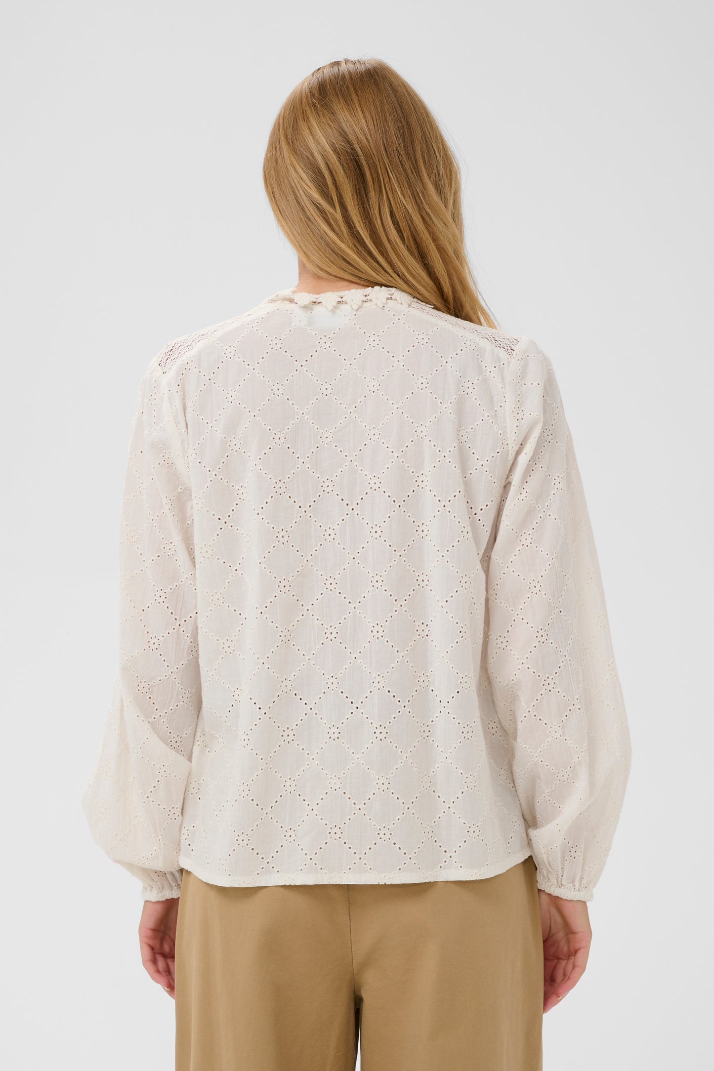 Woman wearing a the Petunia white broderie anglaise blouse 