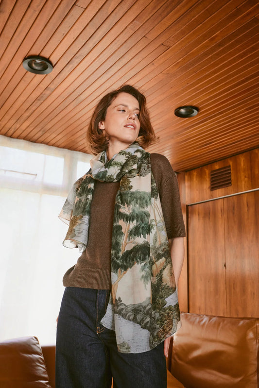 woman wearing the one hundred stars Scarf with rivers and tree landscape on it