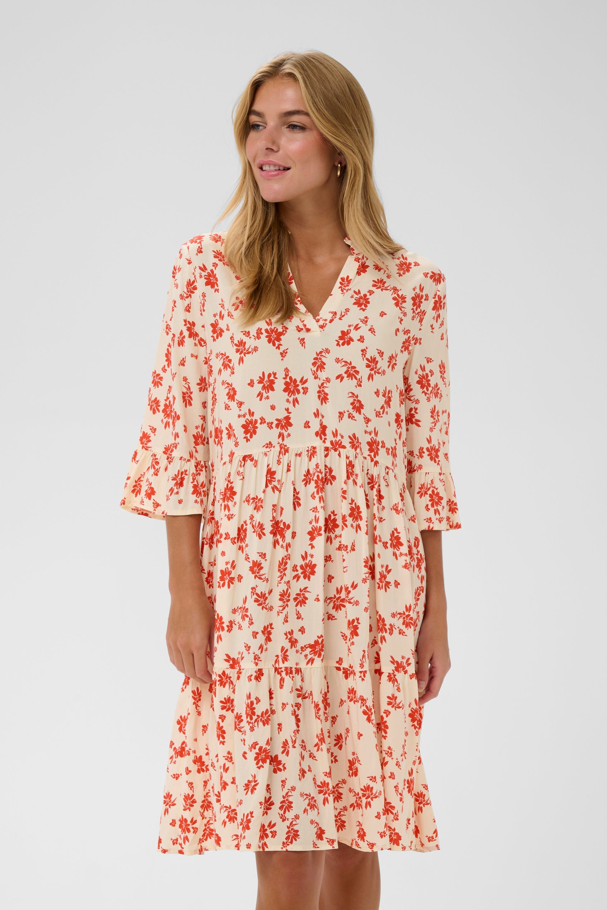 Saint Tropez Eda Dress with 3/4 length sleeves and knee length.  It has organ/red daisy flowers on it