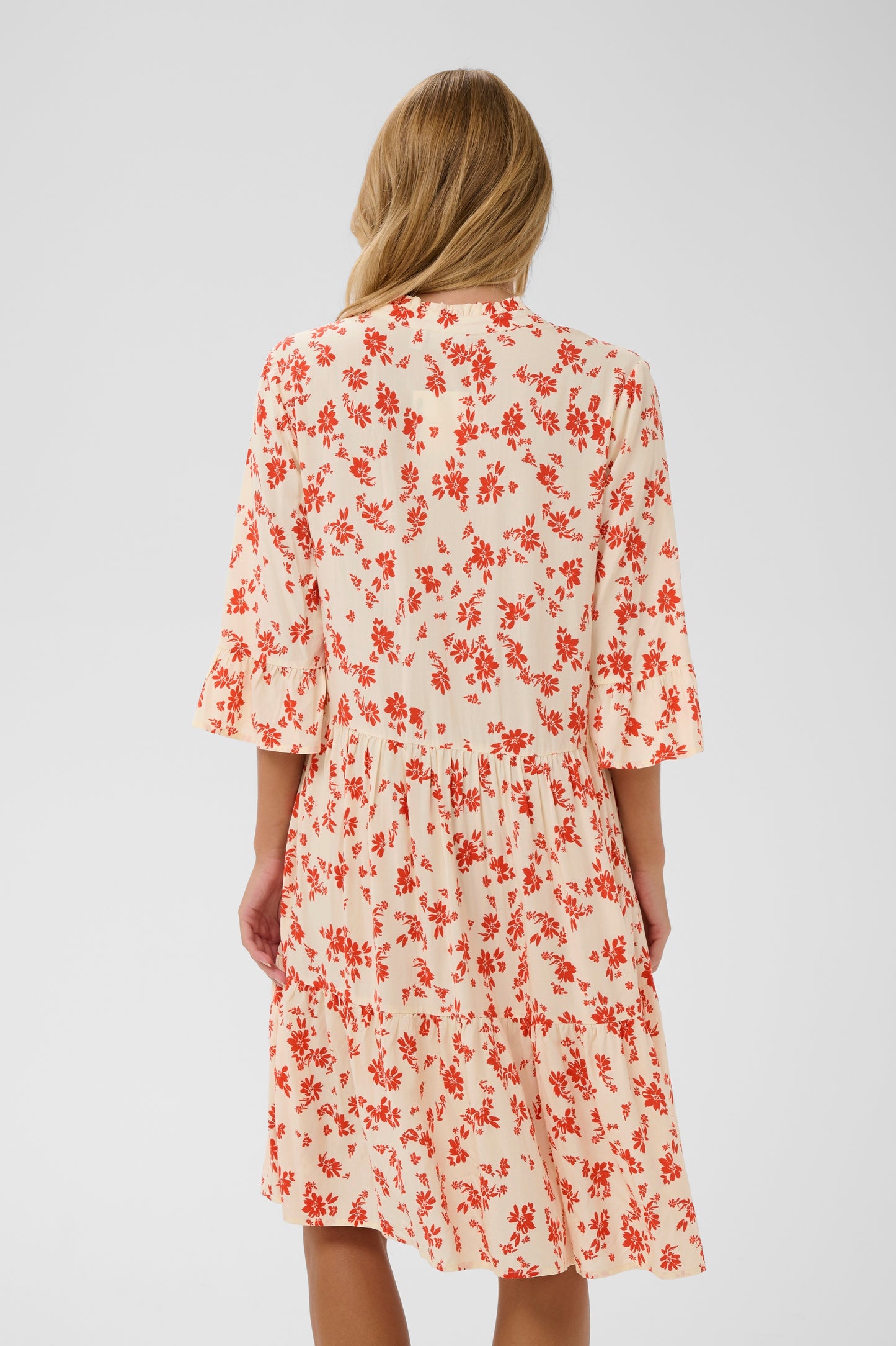 Saint Tropez Eda Dress with 3/4 length sleeves and knee length.  It has organ/red daisy flowers on it