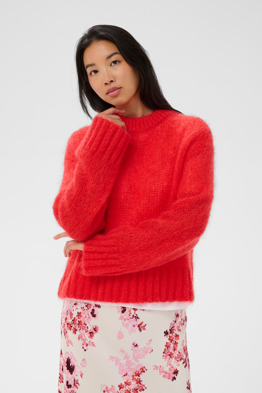Woman wearing a red sweater with a white background