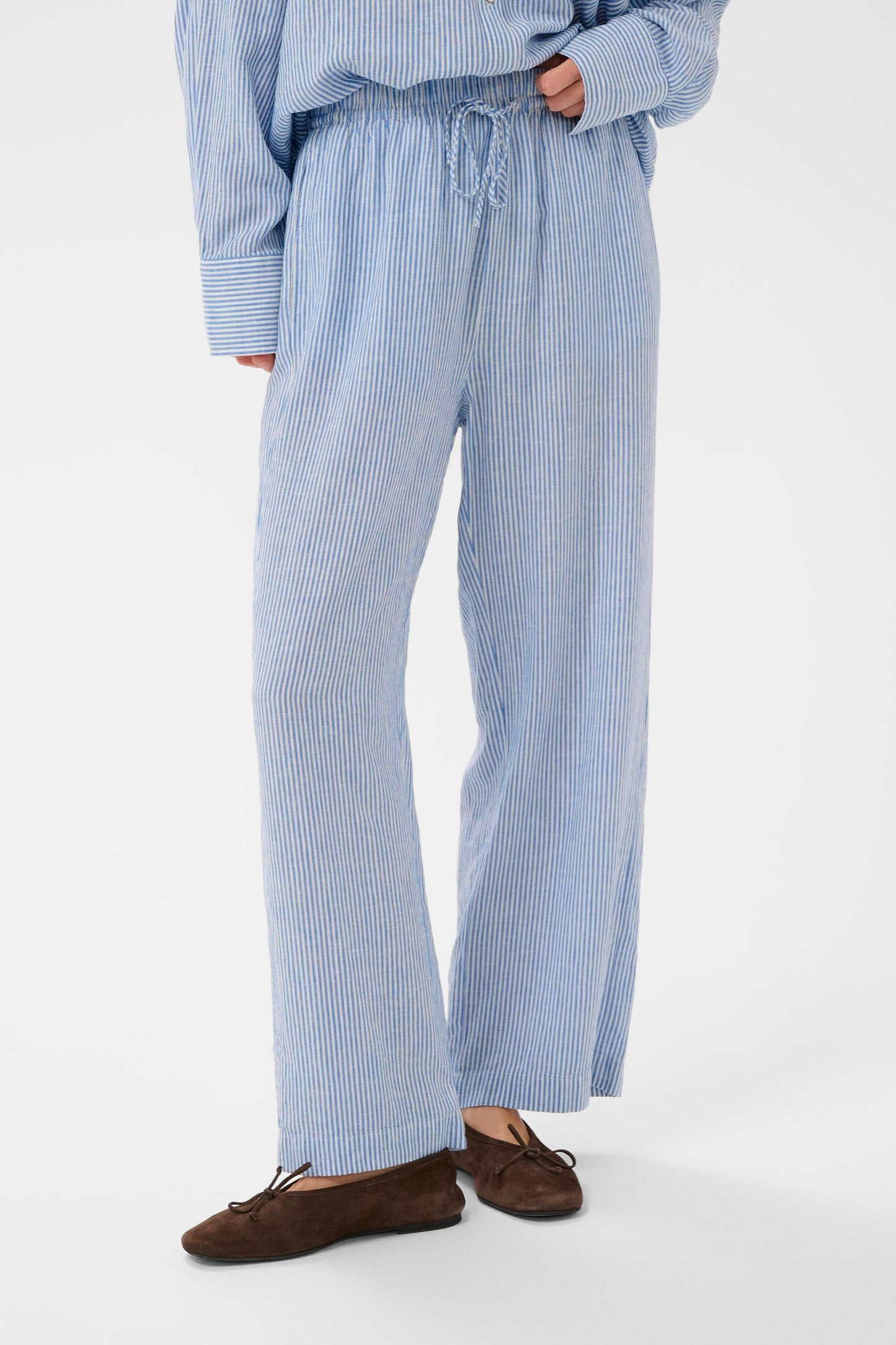 Woman wearing Soaked in Luxury Aria Blue with white fine striped linen trousers