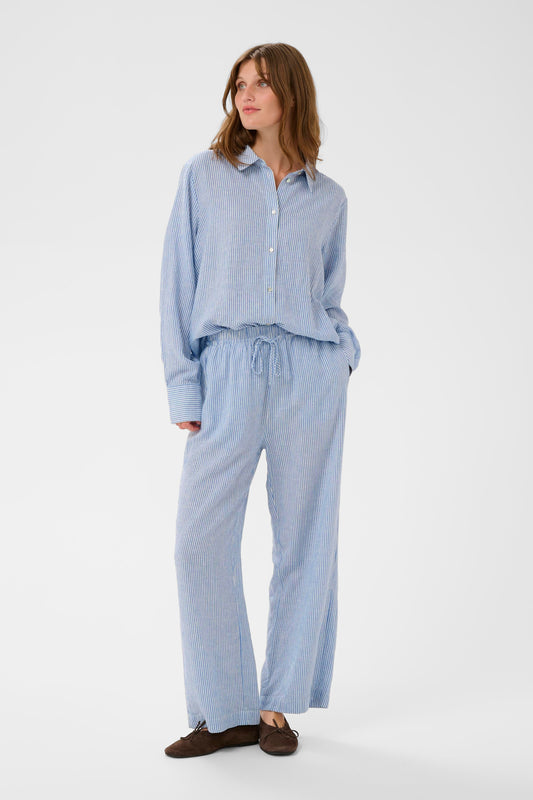 Woman wearing Soaked in Luxury Aria Blue with white fine striped linen trousers