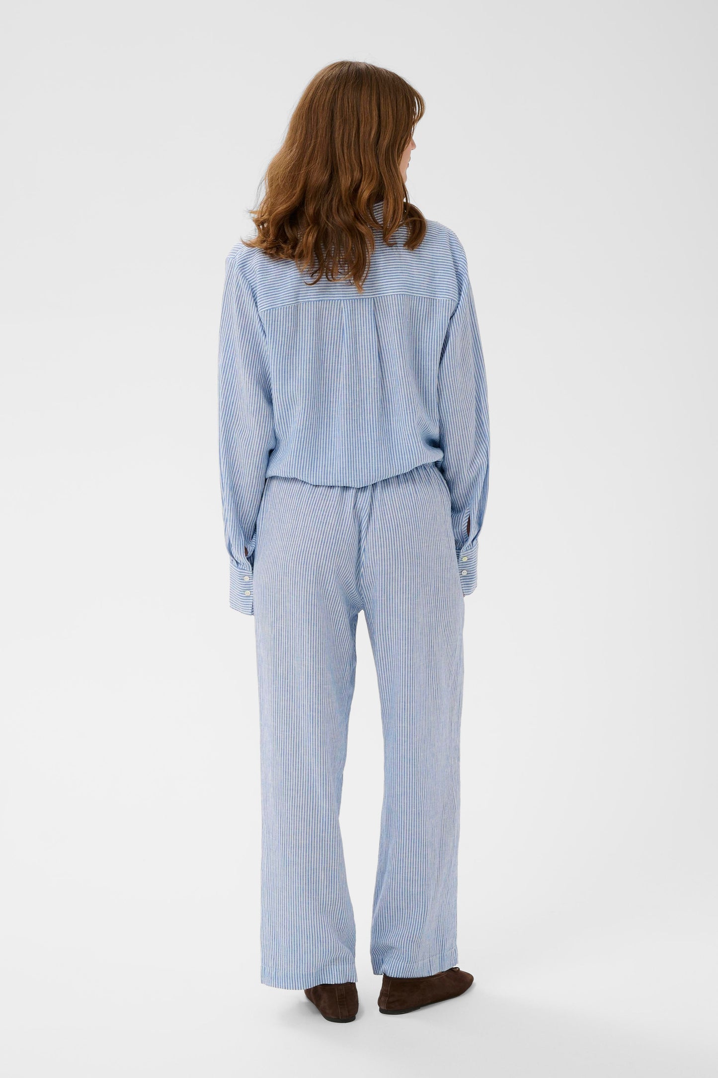 Woman wearing Soaked in Luxury Aria Blue with white fine striped linen trousers