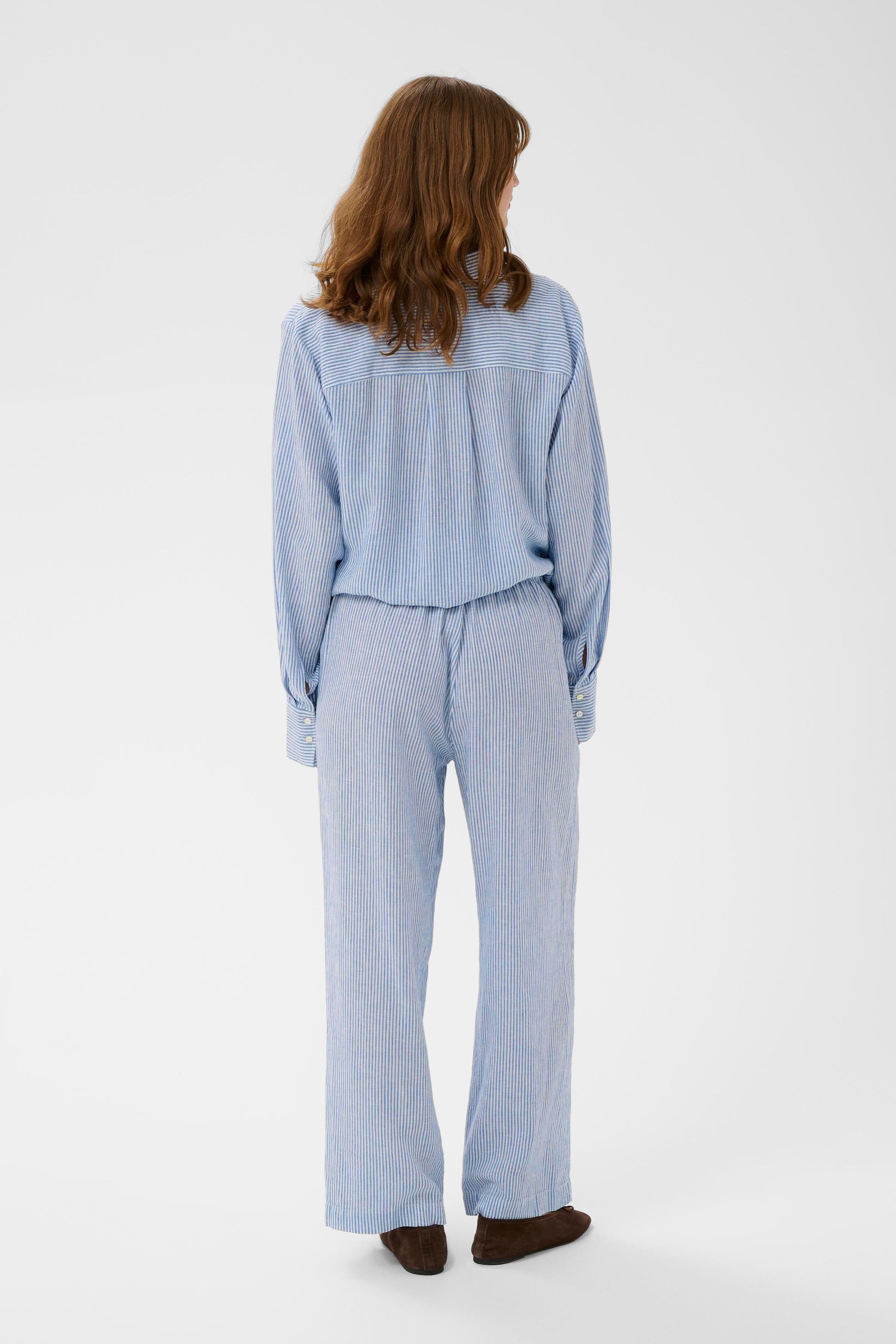 Woman wearing Soaked in Luxury Aria Blue with white fine striped linen trousers