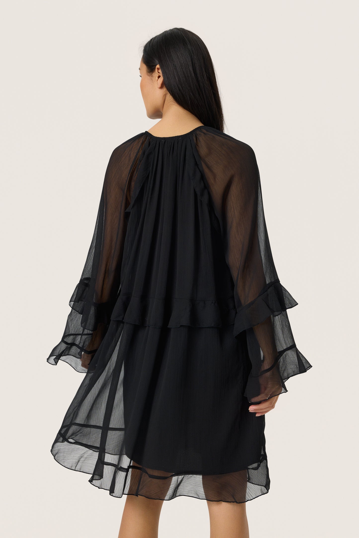Woman wearing the Soaked in Luxury Harietta knee length floaty chiffon dress with long sleeves 