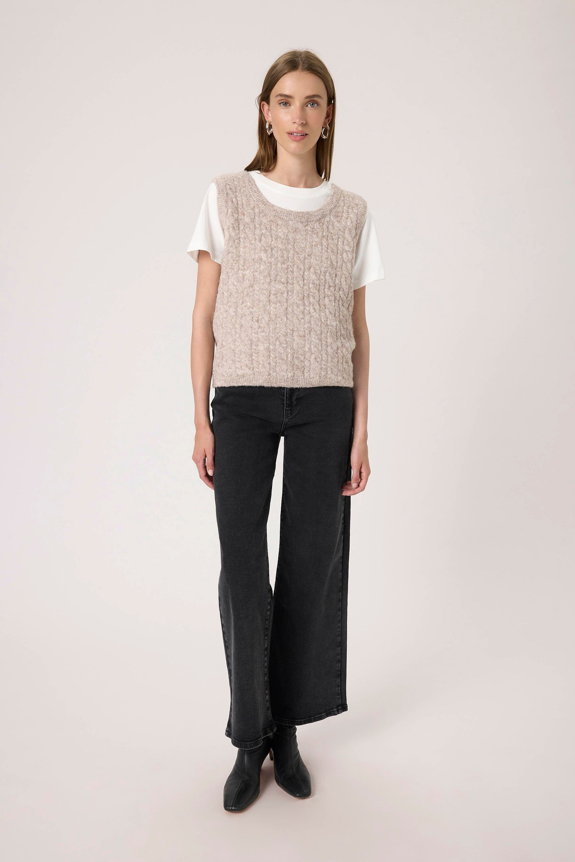 Woman wearing the Soaked in Luxury Vespera beige knitted vest over a white shirt.