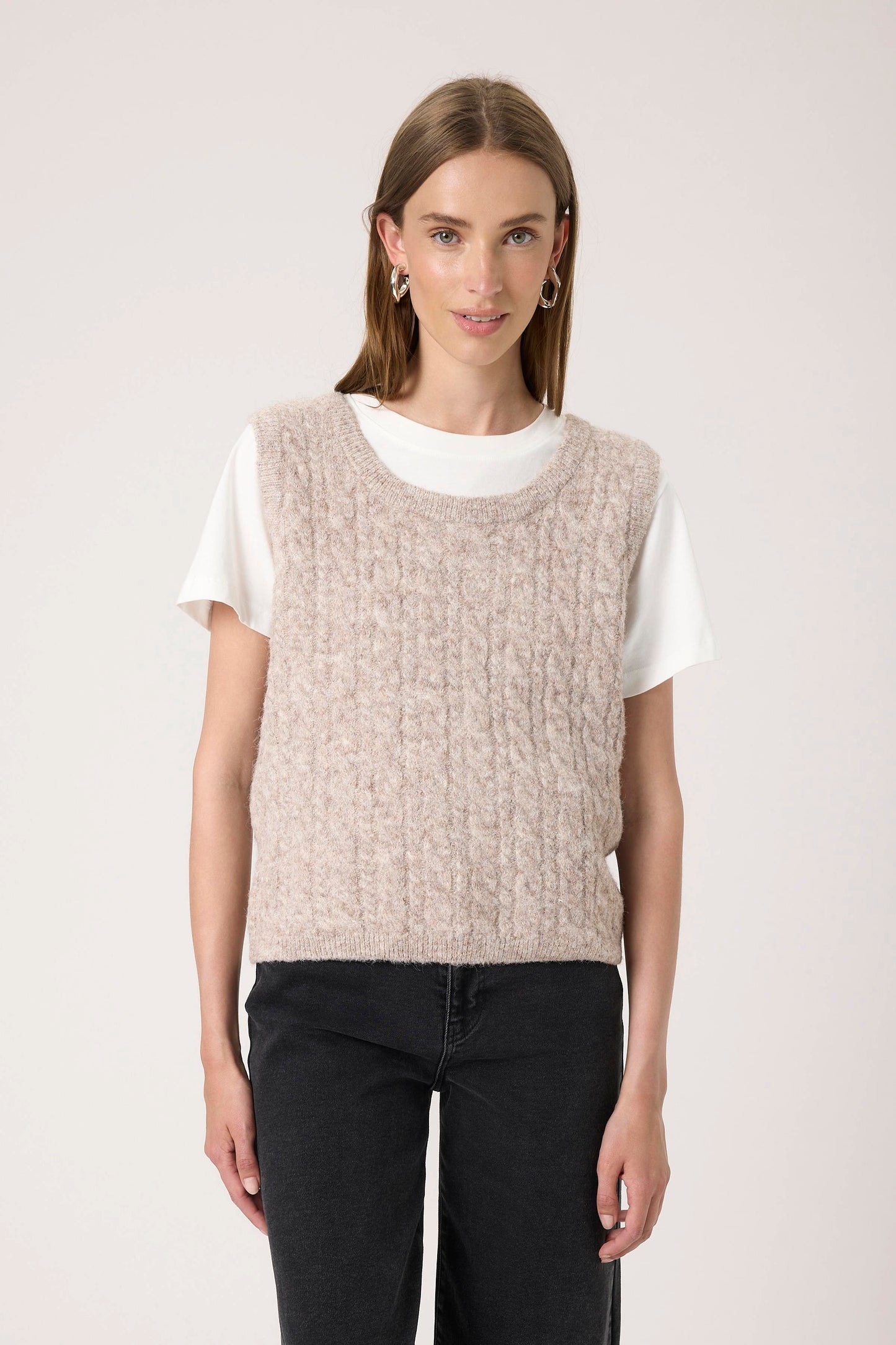 Woman wearing the Soaked in Luxury Vespera beige knitted vest over a white shirt.