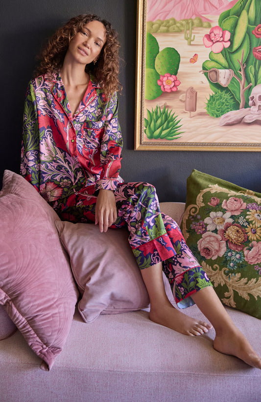 Woman wearing the floral  Marianna satin pyjamas by Hope and Ivy.  In blue, green and pink colours