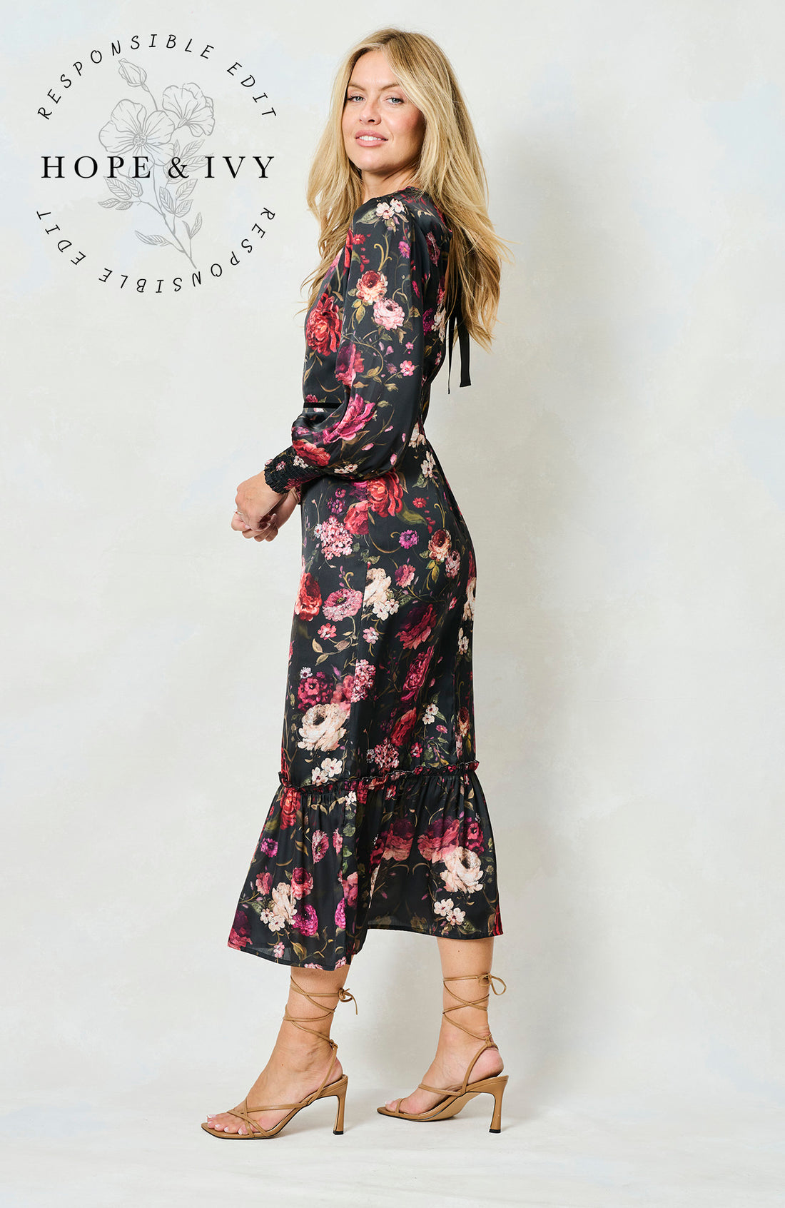 Woman wearing the Holly floral dress with long sleeves on a white background, featuring the brand 'Hope & Ivy'.