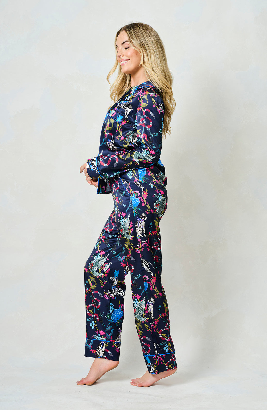 Woman wearing the blue suzanne pyjamas from Hope & Ivy.  Pictures of animals on them