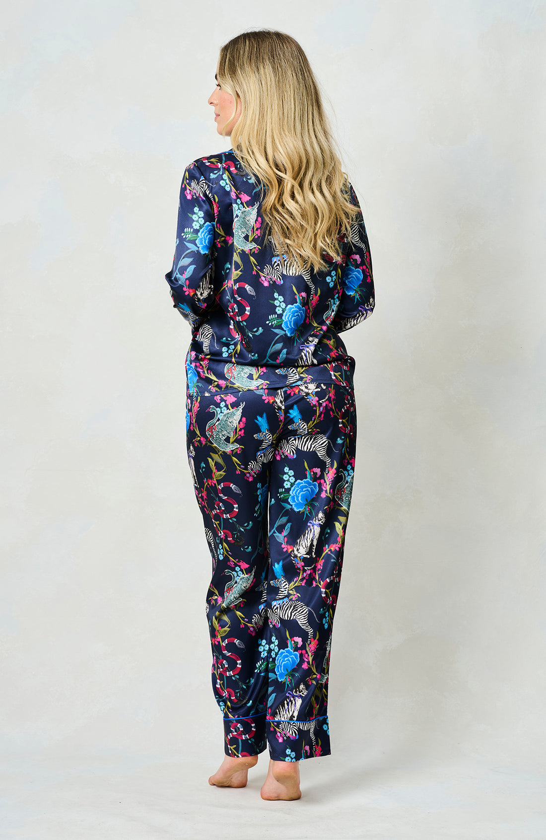 Woman wearing the blue suzanne pyjamas from Hope & Ivy.  Pictures of animals on them