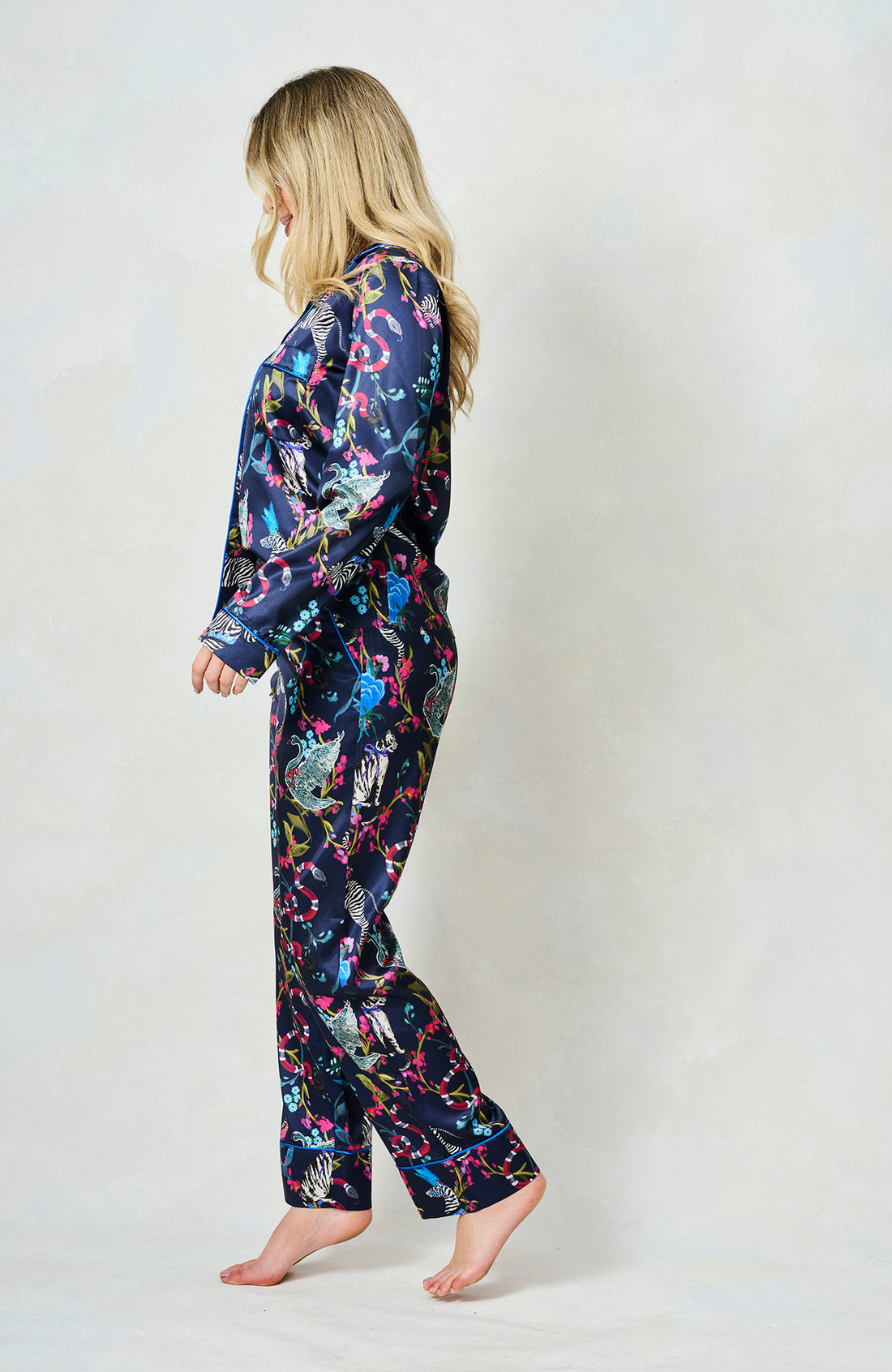 Woman wearing the blue suzanne pyjamas from Hope & Ivy.  Pictures of animals on them