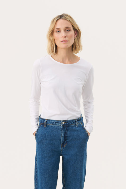 Woman wearing a white long sleeved top and jeans