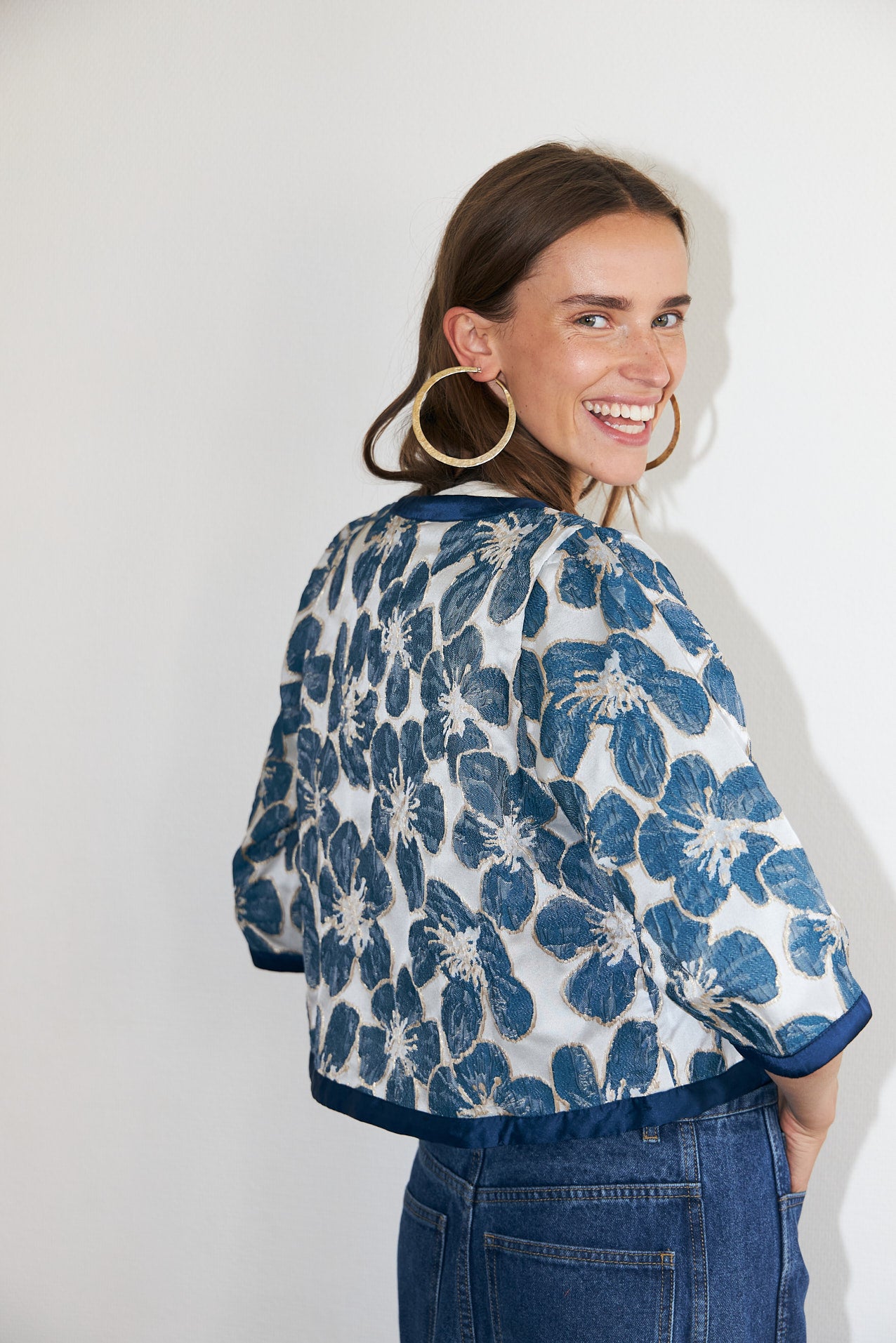 Trine feminine jacket featuring a woven floral design in blue, elegant tie-front fastening and wide sleeves.