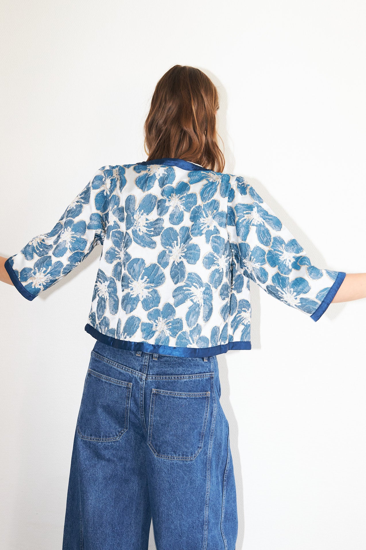 Trine feminine jacket featuring a woven floral design in blue, elegant tie-front fastening and wide sleeves.