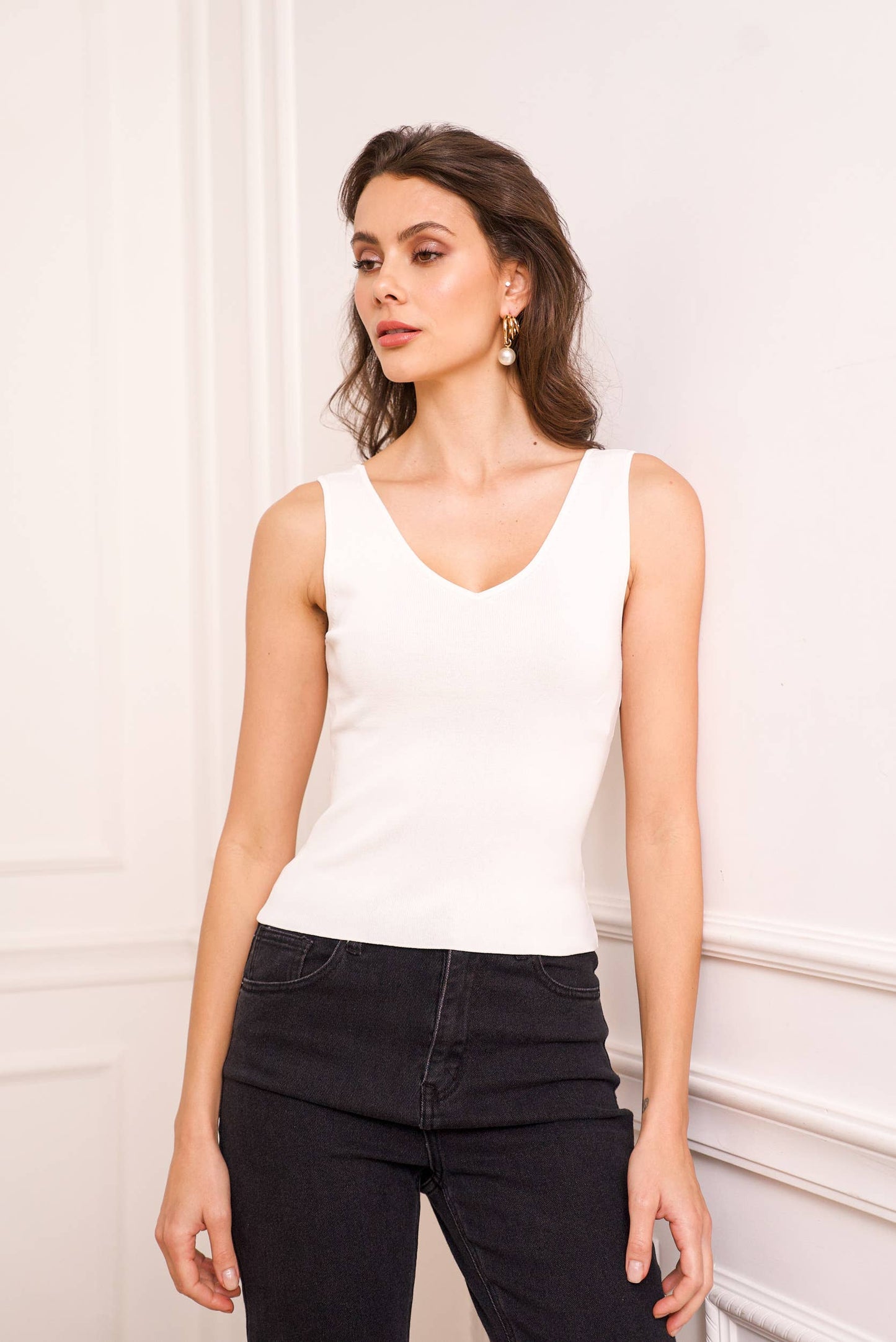 Woman wearing a white sleeveless top with V neck and Square line back