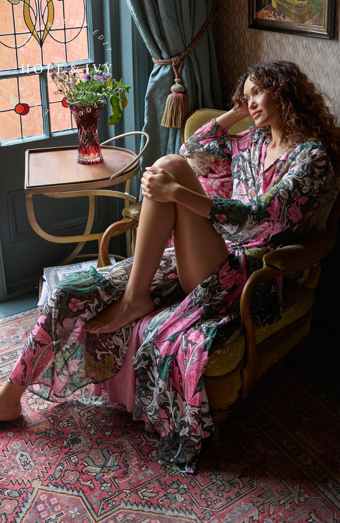 Woman wearing the maxi wrap floral Rosehip dress from Hope & Ivy.  Soft pinks, greens and black.