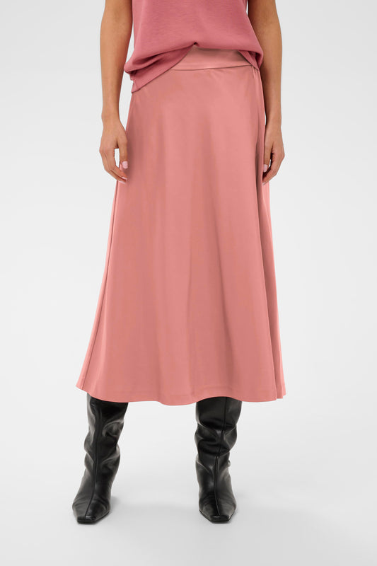 Woman wearing a pink sating skirt and pink Jumper