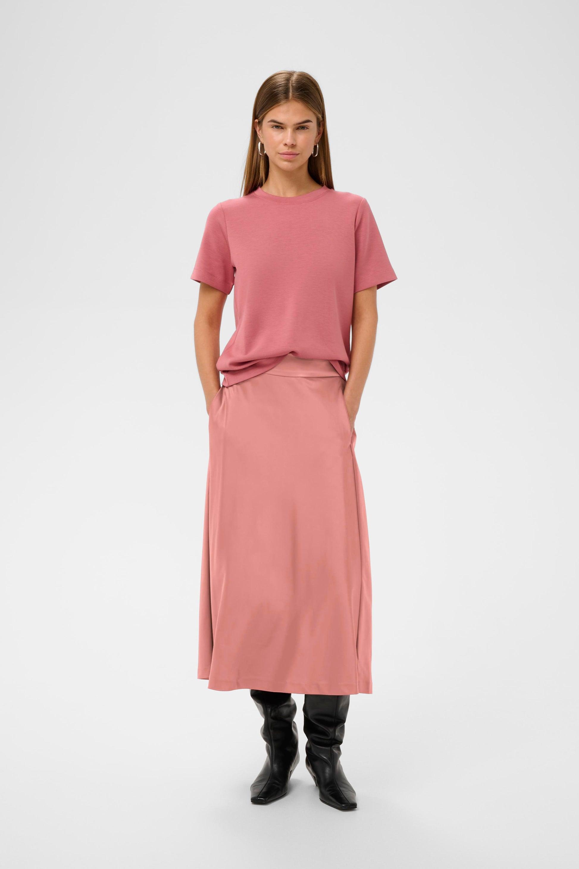 Woman wearing a pink sating skirt and pink Jumper