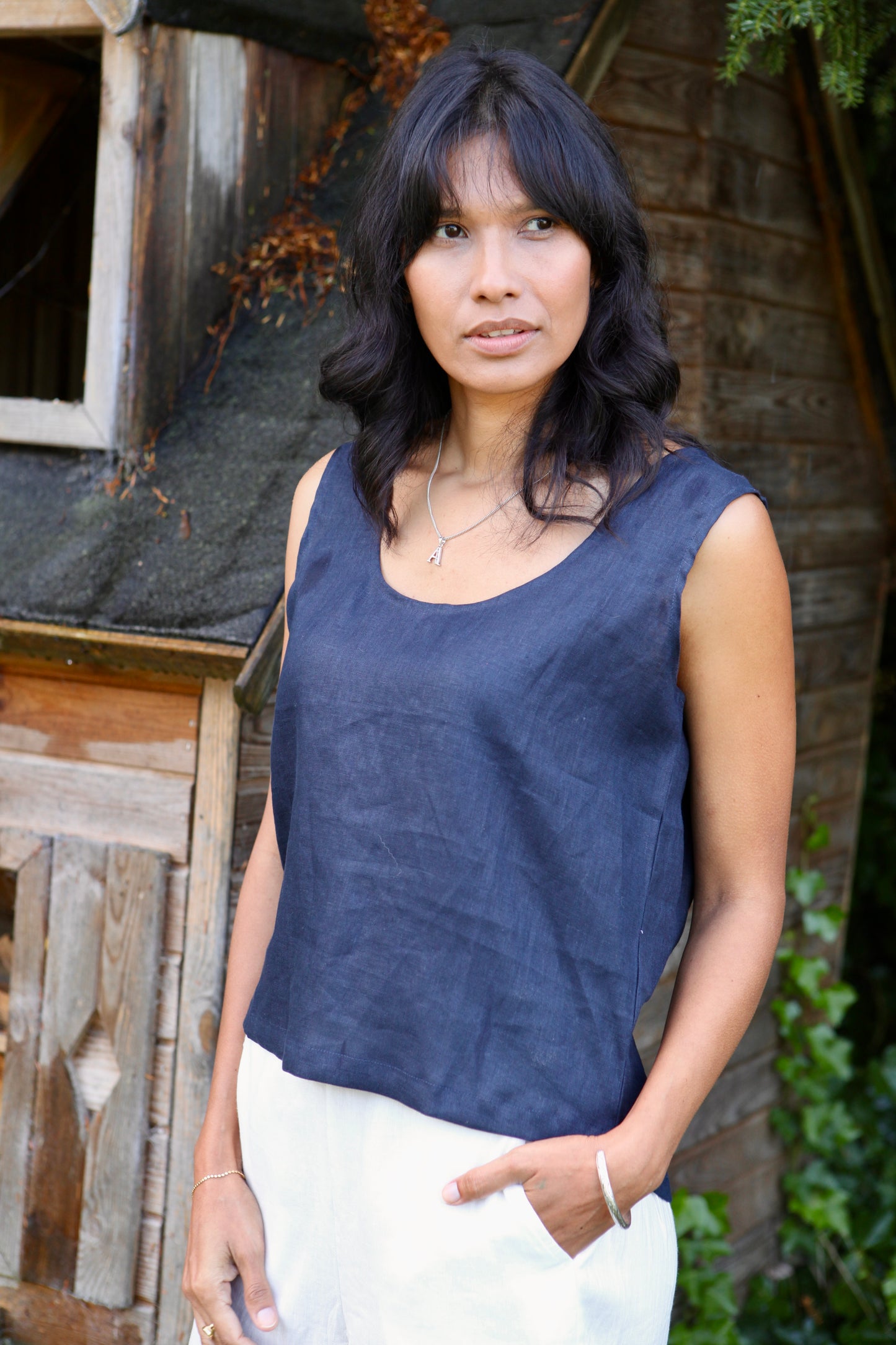 WOman wearing a sleeveless linen top in blue